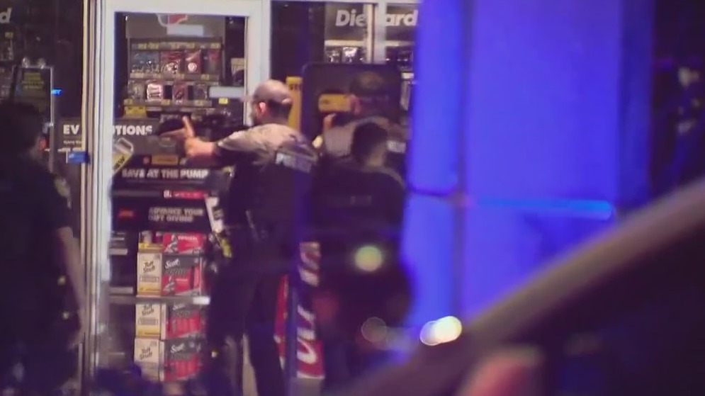 With guns drawn, dozens of police officers enter Orlando auto store off John Young Parkway